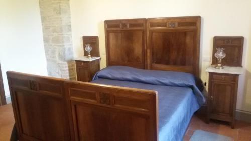 聖塞波爾克羅的住宿－La Collina di Piero，一间卧室配有一张木架床和橱柜。