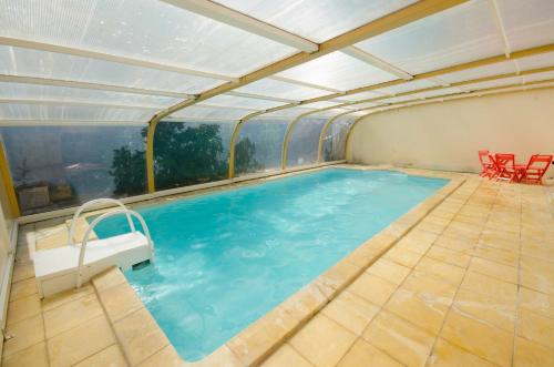 - une piscine dans une maison avec un toit dans l'établissement Joyeux, à Saint-Laurent-de-Céris