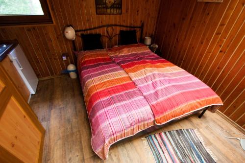 a bedroom with a bed with a colorful blanket on it at Bungalov u Draka Vřesina in Vřesina