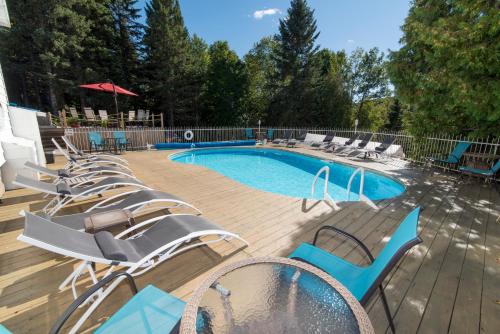 a group of chairs and a swimming pool at Auberge Hotel Spa Watel in Sainte-Agathe-des-Monts