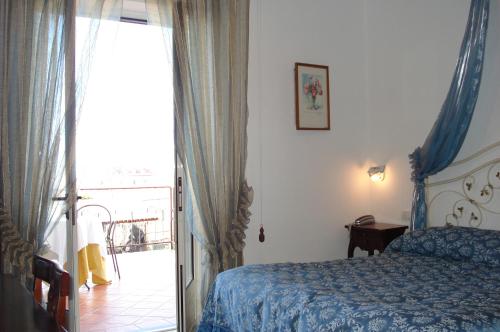 a bedroom with a bed and a door to a balcony at Nido Degli Dei in Agerola
