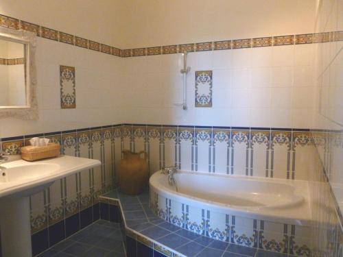 La salle de bains est pourvue d'une baignoire et d'un lavabo. dans l'établissement Château Lagaillarde, à Thil