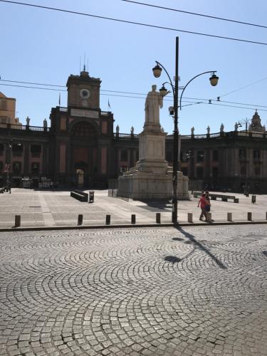 a large building with a clock tower and a statue at L'Approdo di Dante in Naples