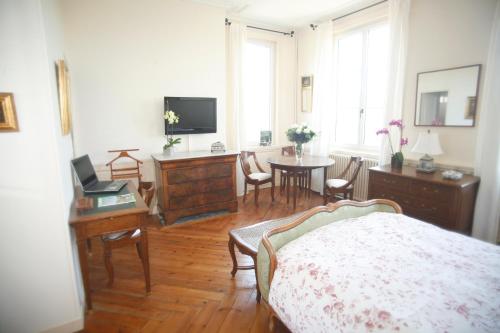 une chambre avec un lit et une table avec des chaises dans l'établissement Chambres d'hotes Autour de la Rose, à Honfleur