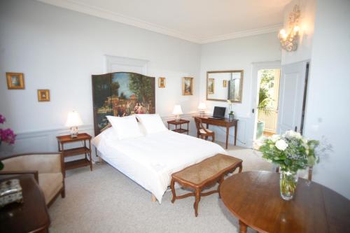 Un dormitorio con una gran cama blanca y una mesa en Chambres d'hotes Autour de la Rose, en Honfleur