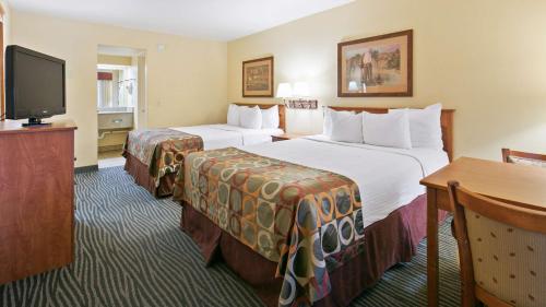 um quarto de hotel com duas camas e uma televisão de ecrã plano em Best Western Desert Inn em Safford