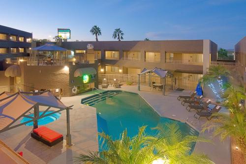 a hotel with a swimming pool in front of a building at Best Western Yuma Mall Hotel & Suites in Yuma