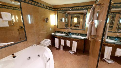 a bathroom with two sinks and a bath tub at Hôtellerie Du Bas-Bréau in Barbizon