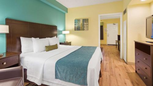 a hotel room with a large bed and a television at Best Western Plus Deerfield Beach Hotel & Suites in Deerfield Beach