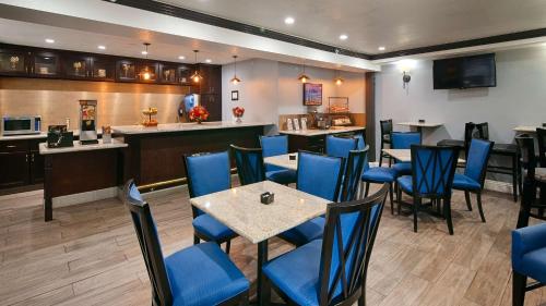 a restaurant with blue chairs and tables and a bar at Best Western Plus Diamond Valley Inn in Hemet