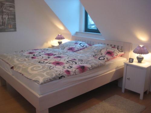 Un dormitorio con una cama blanca con flores. en Ferienhaus Wattenhus, en Büsum