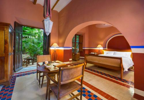 a bedroom with a bed and a desk in a room at Hacienda San Jose Cholul in Tixkokob