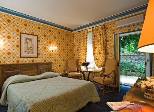 a bedroom with a bed and a table and chairs at Hôtellerie Du Bas-Bréau in Barbizon