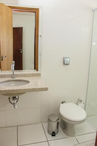 a bathroom with a toilet and a sink at Hotel São Miguel in Sorriso