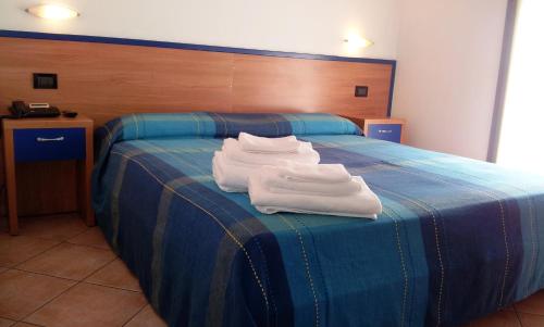 dos toallas blancas sentadas encima de una cama en Hotel Iride, en Milán