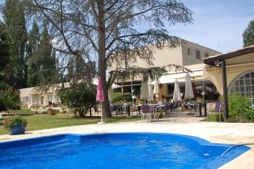 una piscina frente a una casa con patio en Le Fleurance - NOUVELLE équipe - Groupe LOGIS Hôtels en Fleurance