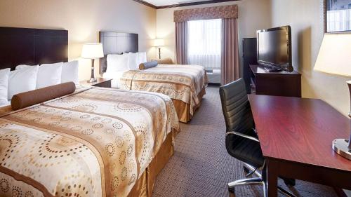a hotel room with two beds and a desk and a television at Best Western Plus Royal Mountain Inn & Suites in Athens