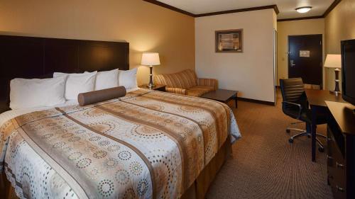 a hotel room with a large bed and a desk at Best Western Plus Royal Mountain Inn & Suites in Athens