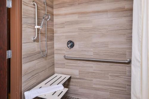 Best Western Plus Rama Inn في ريدموند: كشك للاستحمام مع مقعد في الحمام