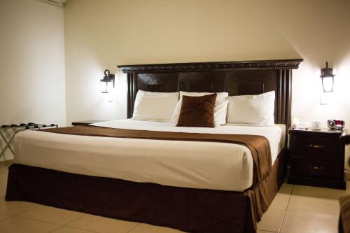 um quarto com uma cama grande e uma cabeceira em madeira em Hotel Go Inn em Monclova