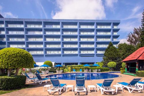 um hotel com cadeiras e uma piscina e um edifício em Best Western PLUS Gran Hotel Morelia em Morelia