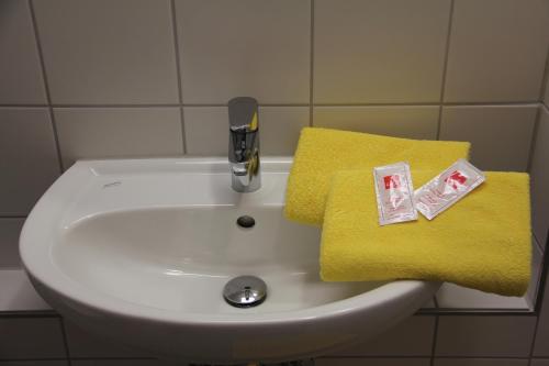 a bathroom sink with a yellow towel and a faucet at Jugendherberge Heidelberg International in Heidelberg