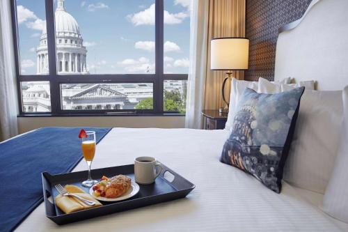 a tray of food and drinks on a bed with the capitol building at Best Western Premier Park Hotel in Madison