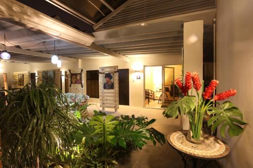 a lobby with plants and mirrors in a building at Casa María Aeropuerto B&B in Alajuela