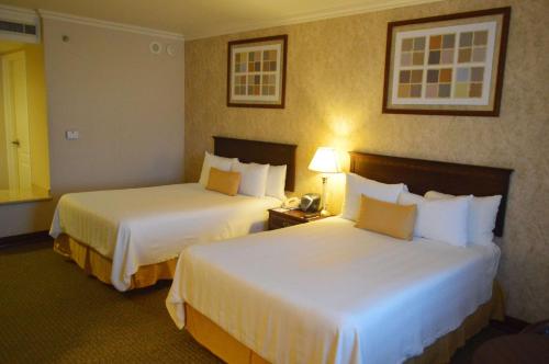 a hotel room with two beds and a telephone at Best Western PLUS Nuevo Laredo Inn & Suites in Nuevo Laredo
