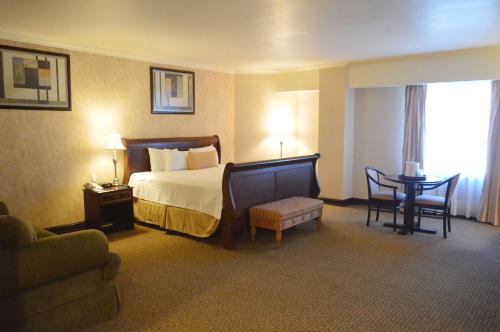a hotel room with a bed and a table and chairs at Best Western PLUS Nuevo Laredo Inn & Suites in Nuevo Laredo