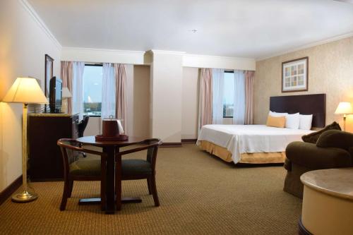 Habitación de hotel con cama, mesa y sofá en Best Western PLUS Nuevo Laredo Inn & Suites en Nuevo Laredo