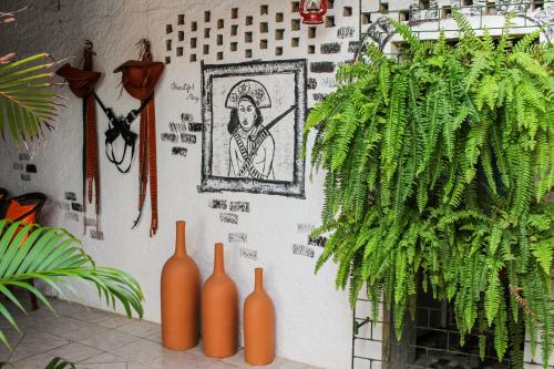 a wall with orange vases and a painting on it at Vila Aju - Pousada Temática in Aracaju