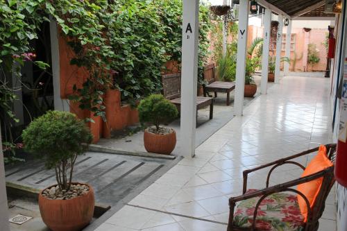 a corridor with benches and potted plants in a building at Vila Aju - Pousada Temática in Aracaju
