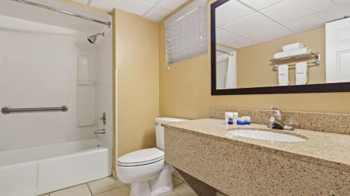 a bathroom with a toilet and a sink and a mirror at Best Western Fort Myers Waterfront in North Fort Myers