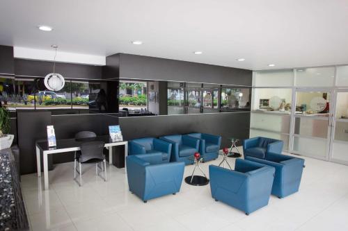 a waiting room with blue chairs and a table at Best Western Plus Gran Hotel Centro Historico in Guadalajara
