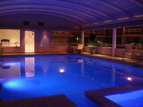 a large swimming pool in a hotel at night at HM Mirador in Chihuahua