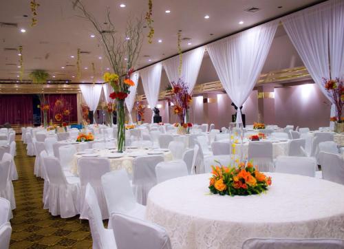 a banquet hall with white tables and white chairs at HM Mirador in Chihuahua