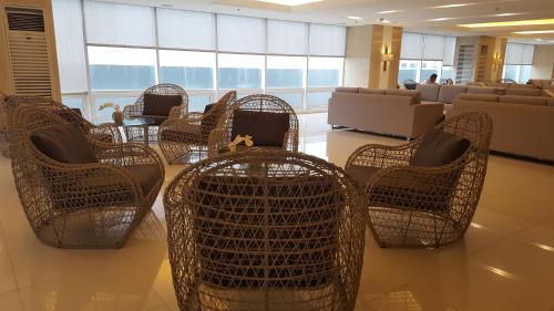 a lobby with wicker chairs and a waiting room at Breeze Residences by CS Luxe in Manila