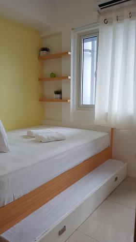 a bedroom with two beds and a window at Breeze Residences by CS Luxe in Manila