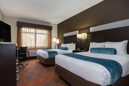 a hotel room with two beds and a television at Best Western Plus Pineville-Charlotte South in Charlotte