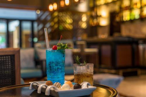 a drink and a plate of food on a table at The Seminyak Beach Resort & Spa in Seminyak