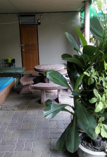 a patio with a picnic table and a wooden door at Anurak Guesthouse in Bangkok
