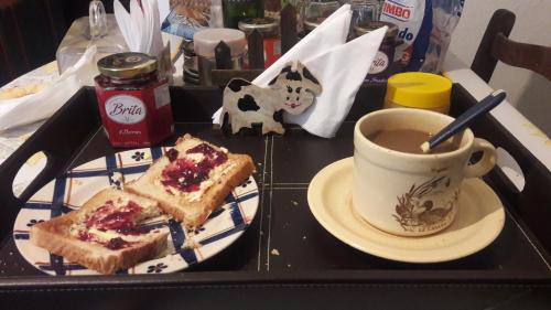 ein schwarzes Tablett mit einem Sandwich und einer Tasse Kaffee in der Unterkunft Estancia Hosteria El Ceibo in Florida