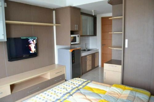 um quarto com uma cozinha com uma cama e uma televisão em DSR Apartment Margonda Residence 2 em Depok