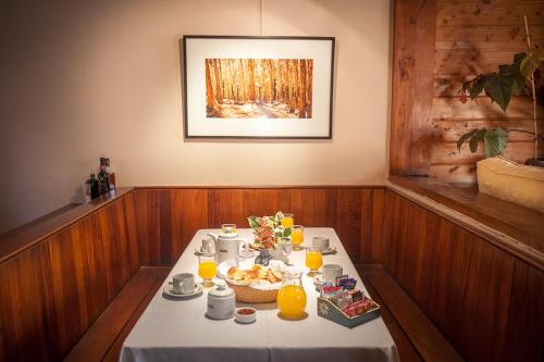 a table with a plate of food and orange juice at Apart Hotel La Bora in San Martín de los Andes