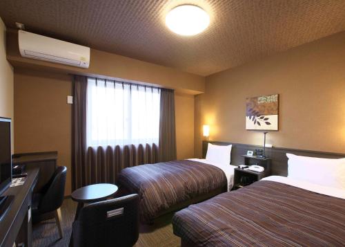 Giường trong phòng chung tại Hotel Route Inn Osaka Izumi -Kishiwada Izumi Inter-