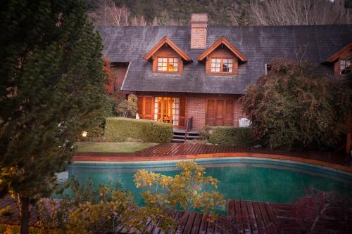 a house with a swimming pool in front of it at Apart Hotel La Bora in San Martín de los Andes