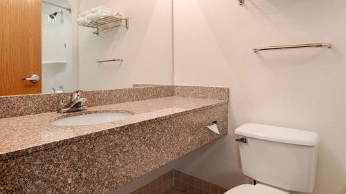 W łazience znajduje się umywalka, toaleta i lustro. w obiekcie Best Western Garden Inn w mieście Bentleyville