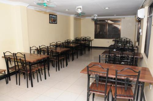 une salle remplie de tables et de chaises dans un restaurant dans l'établissement Safari Inn, à Dar es Salaam