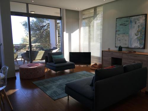 uma sala de estar com um sofá e cadeiras e uma televisão em Jardins En Ville em Bastia